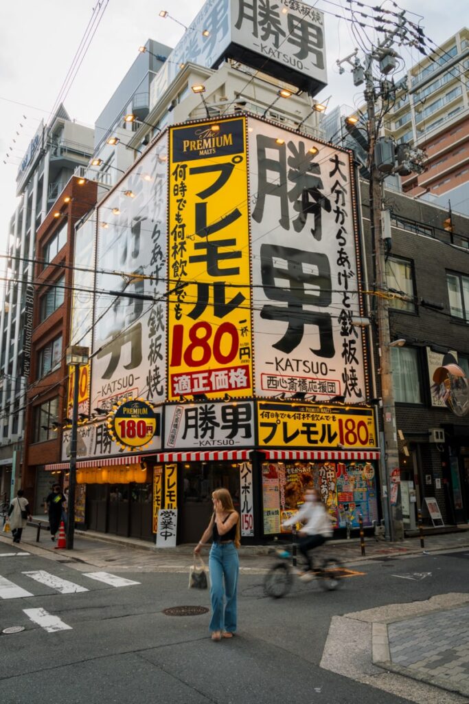A female digital nomad crossing the street in Osaka with artsy background.