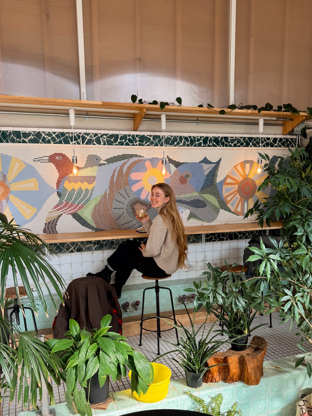 Travel blogger and digital nomad (Bri), author of nomadinjapan.com blog, sitting at coffee bar inside a retro Japanese bathhouse (Tokyo).